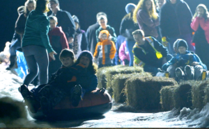 Families sledding down Center St. in Rutland, VT during Winter Fest.